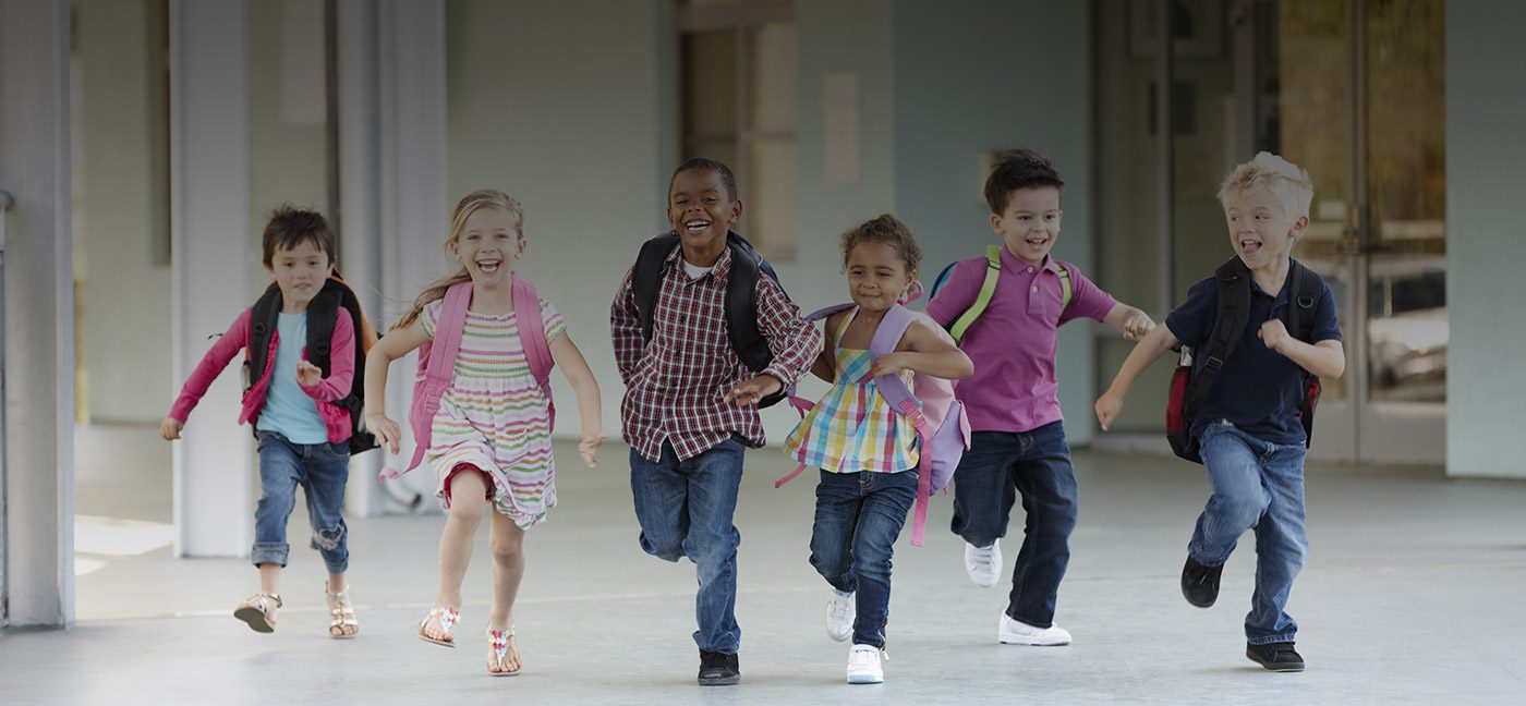 Group of young children running from school