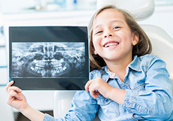 Little girl holding dental x-rays