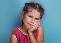 Little girl with toothache holding cheek