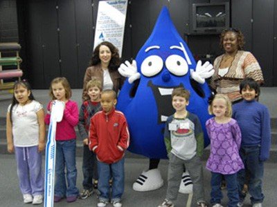 Young children posing with mascot