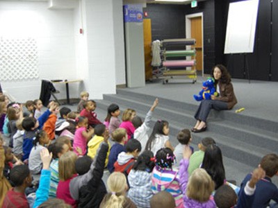 Kids watching team member teach about oral hygiene in auditorium