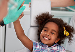 Little girl giving dentist hi five