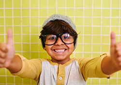 Smiling little boy giving thumbs up