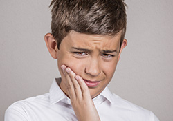 Little boy holding jaw in pain