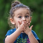 Little girl covering mouth